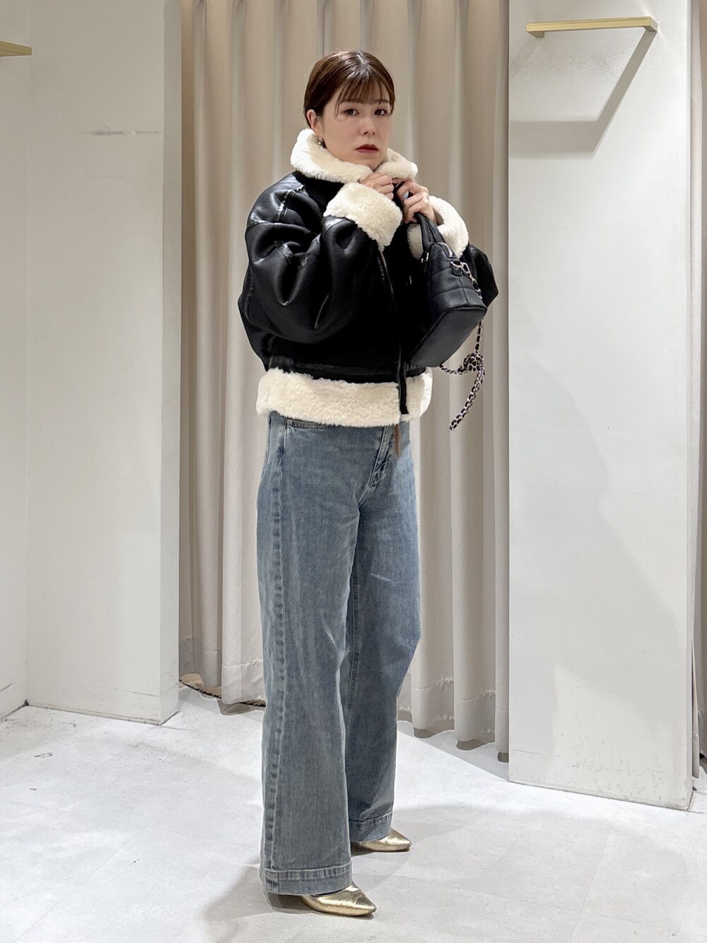 ブラウン系のニット/セーター、ブルー系のデニムパンツ、ブラック系のトートバッグを着用したレディースの秋コーディネートの4枚目の写真