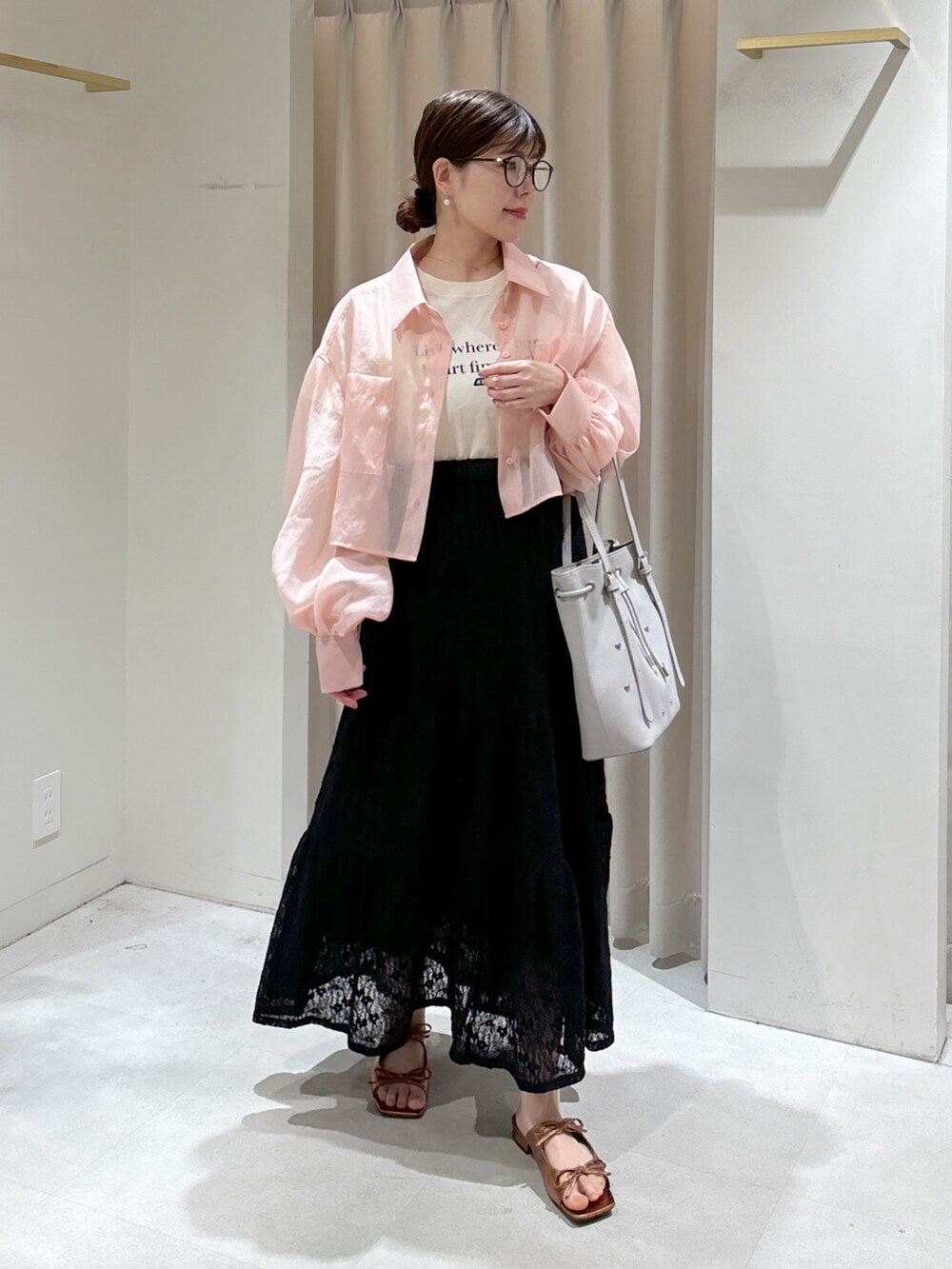 ホワイト系のTシャツ/カットソー、ブラック系のスカート、グレー系のトートバッグを着用したレディースの春コーディネートの6枚目の写真