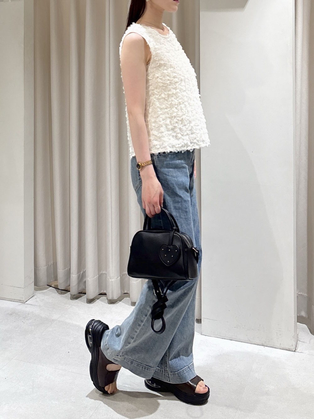 ホワイト系のシャツ/ブラウス、ブルー系のデニムパンツ、ブラック系のボストンバッグを着用したレディースの春コーディネートの2枚目の写真