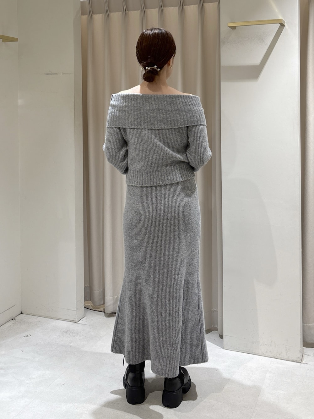 グレー系のワンピース、レッド系のショルダーバッグ、ブラック系のブーツを着用したレディースの秋コーディネートの3枚目の写真