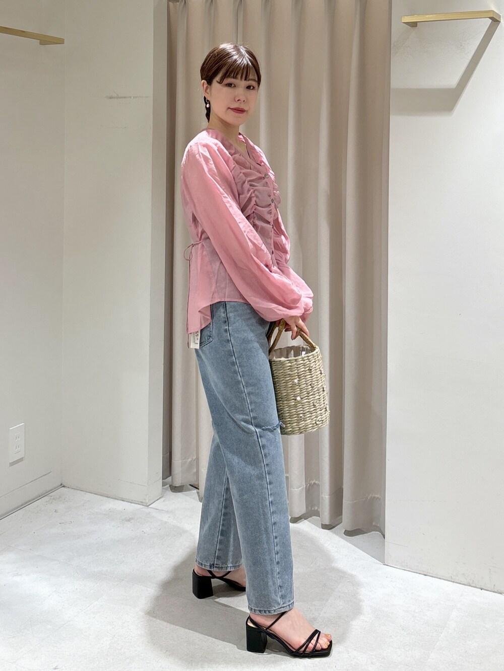 ピンク系のシャツ/ブラウス、イエロー系のかごバッグ、ブルー系のデニムパンツを着用したレディースの春コーディネートの6枚目の写真