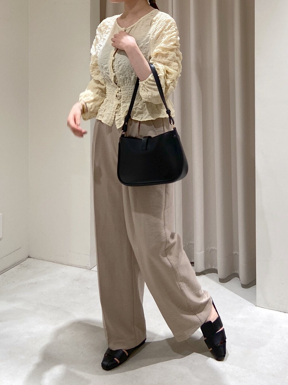 ベージュ系のテーラードジャケット、ホワイト系のスラックス、ホワイト系のカーディガン/ボレロを着用したレディースの春コーディネートの7枚目の写真