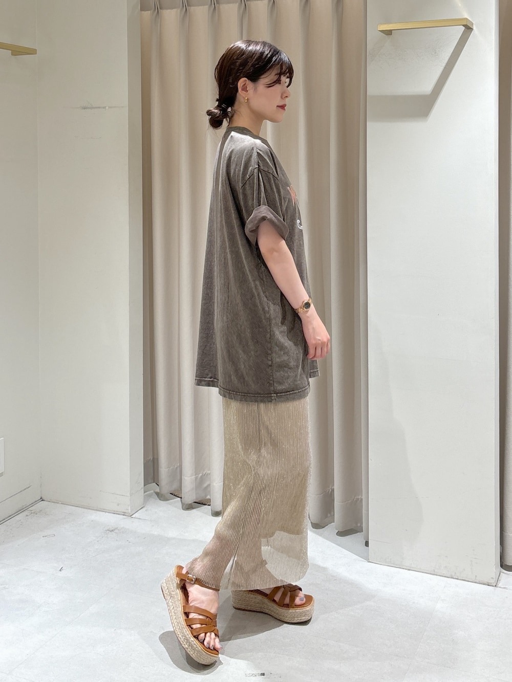 ブラウン系のTシャツ/カットソー、ゴールド系のスカート、グリーン系のショルダーバッグを着用したレディースの夏コーディネートの3枚目の写真