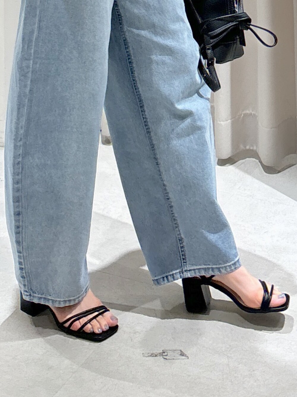 ホワイト系のシャツ/ブラウス、ブラック系のショルダーバッグ、ブルー系のデニムパンツを着用したレディースの夏コーディネートの8枚目の写真