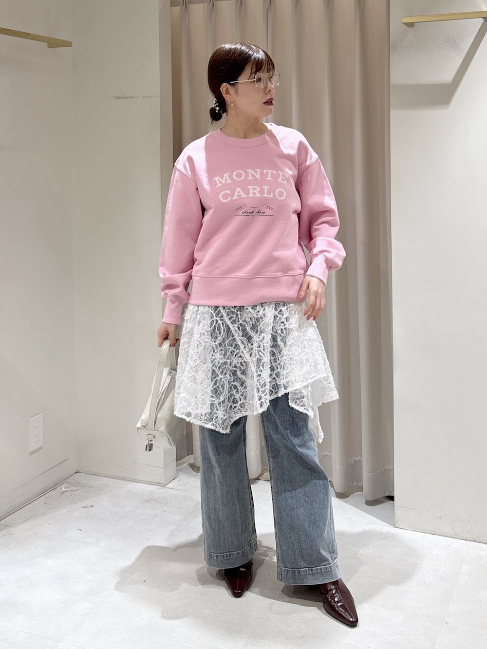 ピンク系のスウェット、ホワイト系のスカート、ブルー系のデニムパンツを着用したレディースの冬コーディネートの4枚目の写真