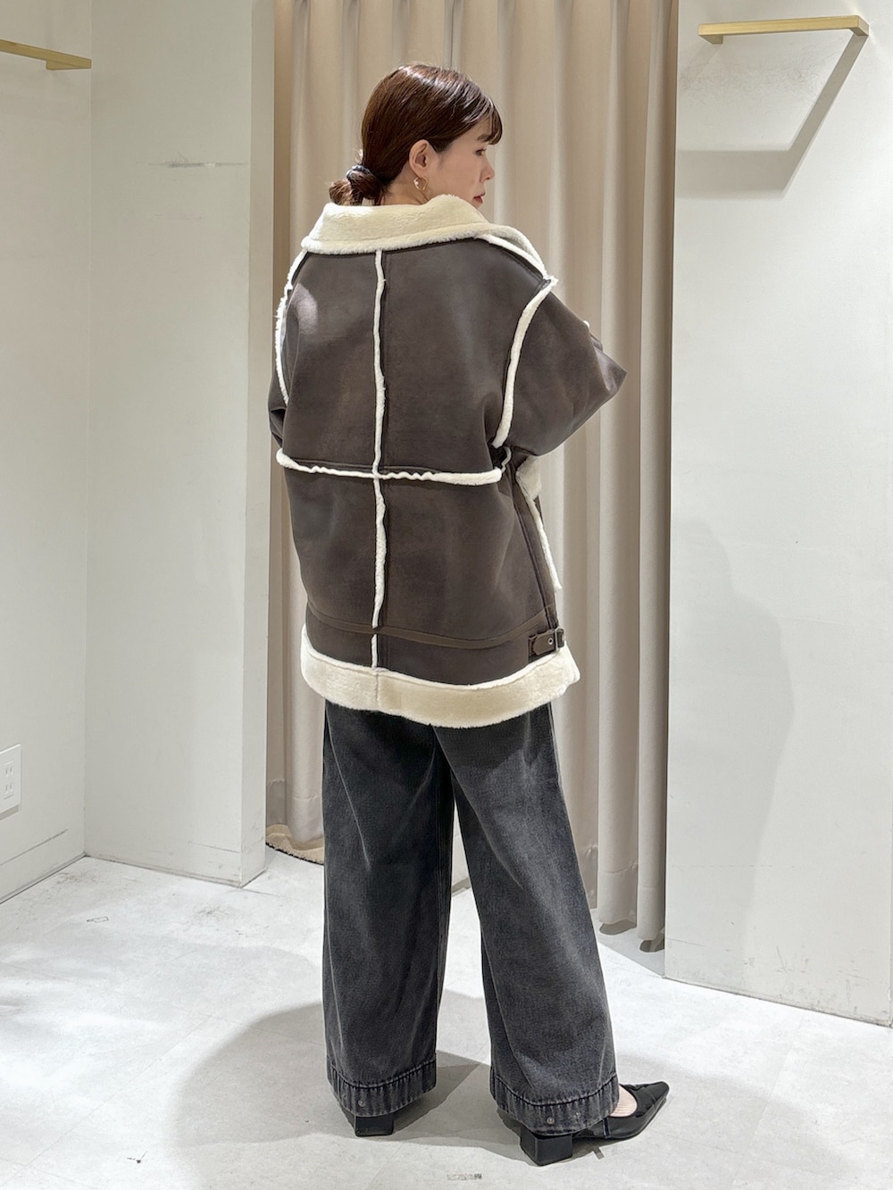 ブラウン系のブルゾン、ブラック系のデニムパンツ、ブラック系のハンドバッグを着用したレディースの秋コーディネートの4枚目の写真