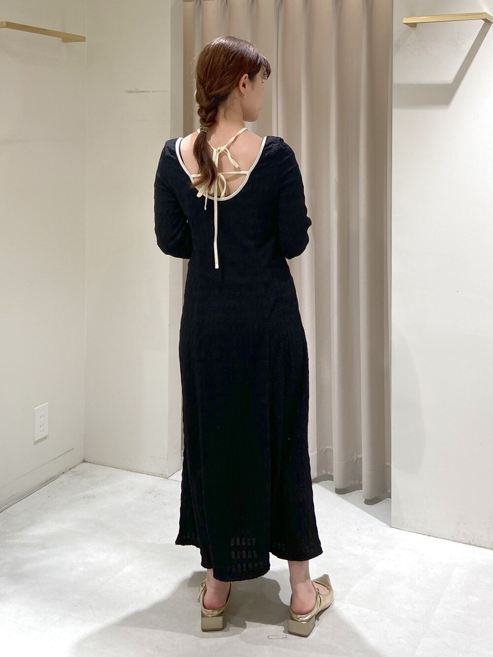 ブラック系のワンピース、ベージュ系のショルダーバッグ、ゴールド系のパンプスを着用したレディースの春コーディネートの6枚目の写真