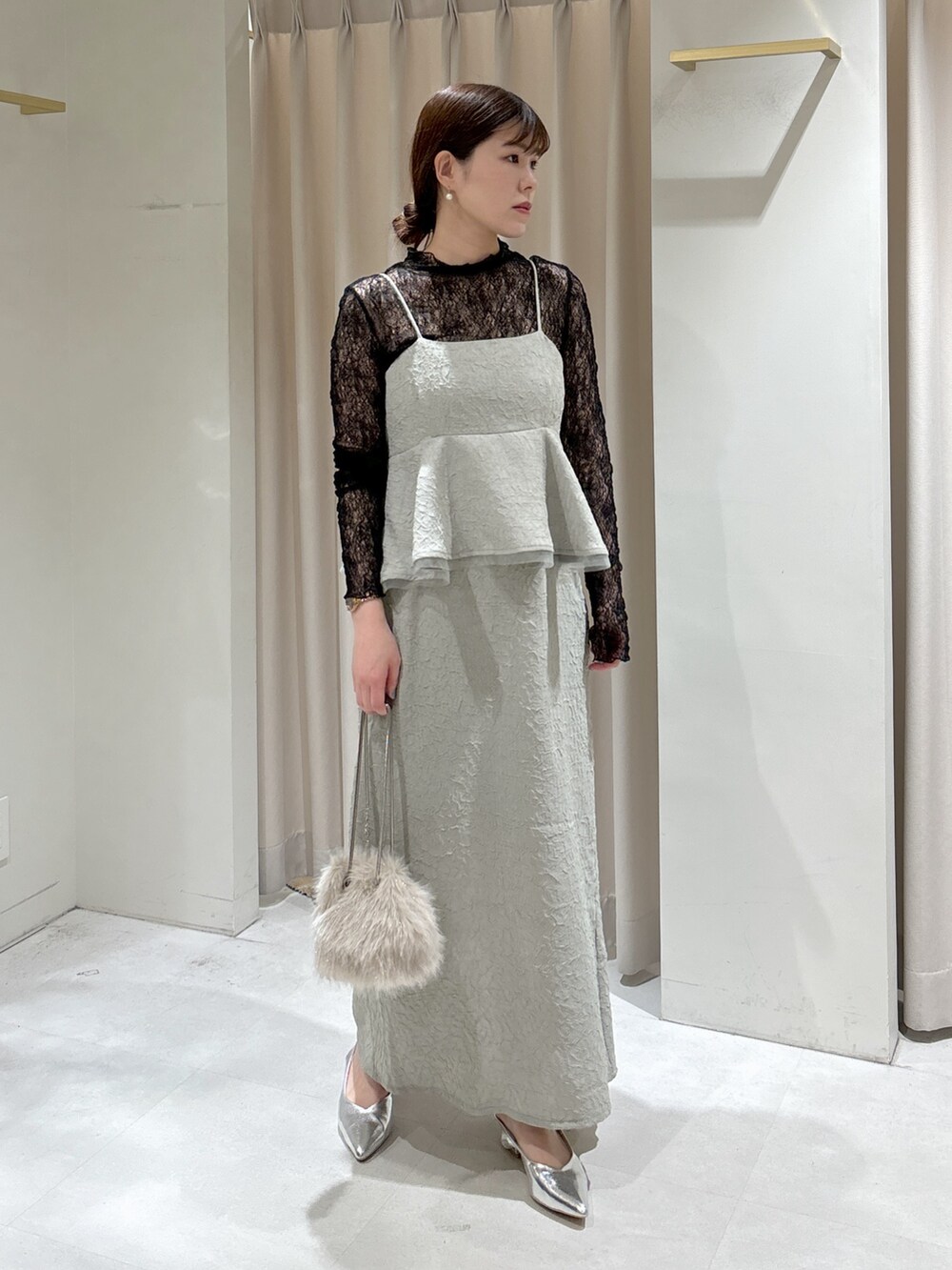 グリーン系のワンピース、ブラック系のTシャツ/カットソー、ベージュ系のショルダーバッグを着用したレディースの冬コーディネートの7枚目の写真