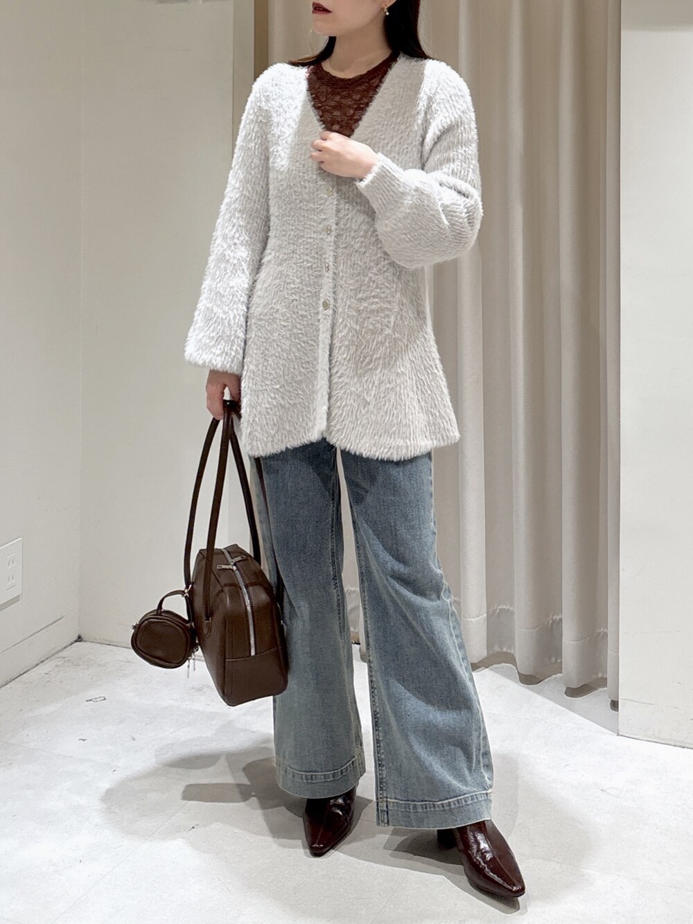 グレー系のニット/セーター、ブラウン系のTシャツ/カットソー、ブラウン系のトートバッグを着用したレディースの秋コーディネートの5枚目の写真