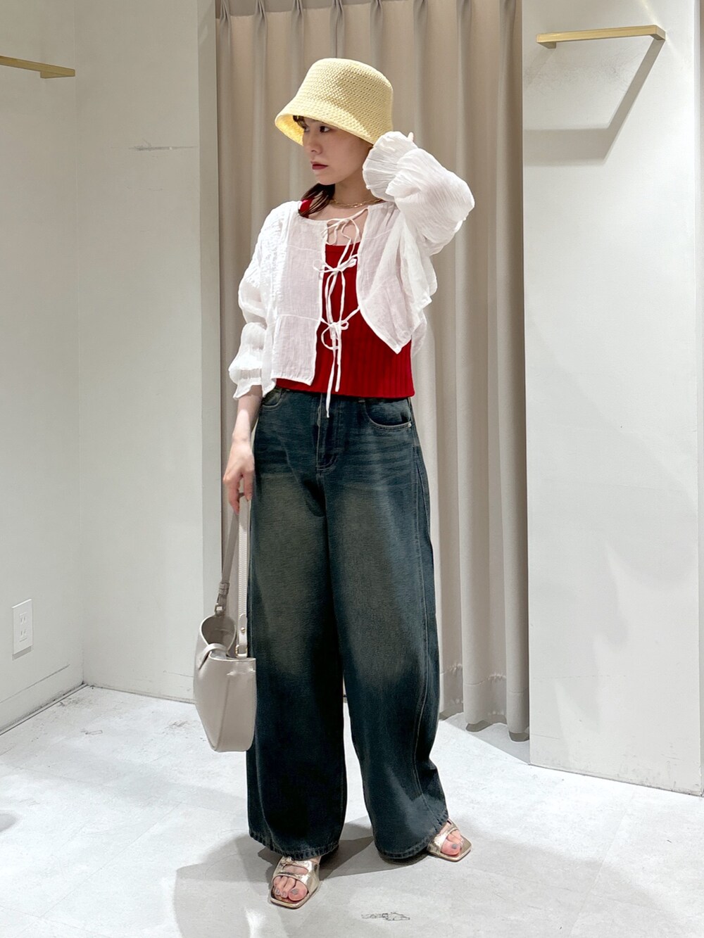 レッド系のタンクトップ、ブルー系のデニムパンツ、グレー系のショルダーバッグを着用したレディースの夏コーディネートの3枚目の写真