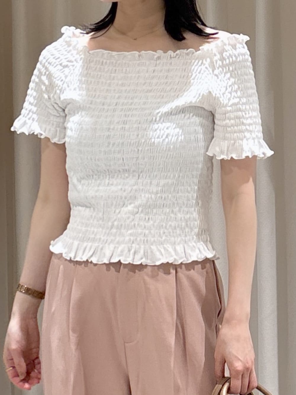 ホワイト系のTシャツ/カットソー、ピンク系のスラックス、ブラウン系のハンドバッグを着用したレディースの夏コーディネートの4枚目の写真