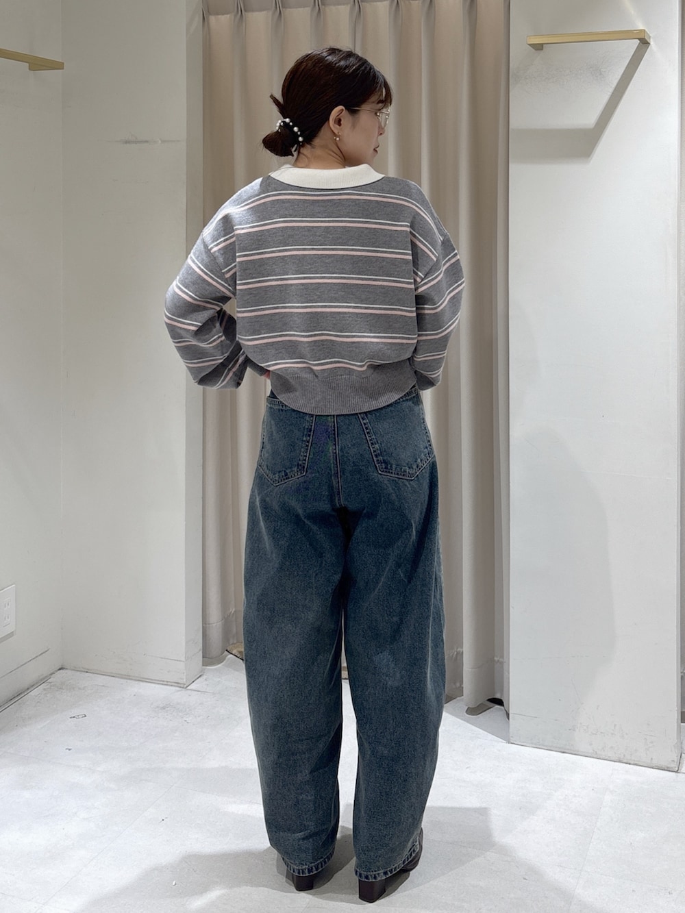 グレー系のニット/セーター、ブラック系のトートバッグ、ブラウン系のパンプスを着用したレディースの冬コーディネートの3枚目の写真