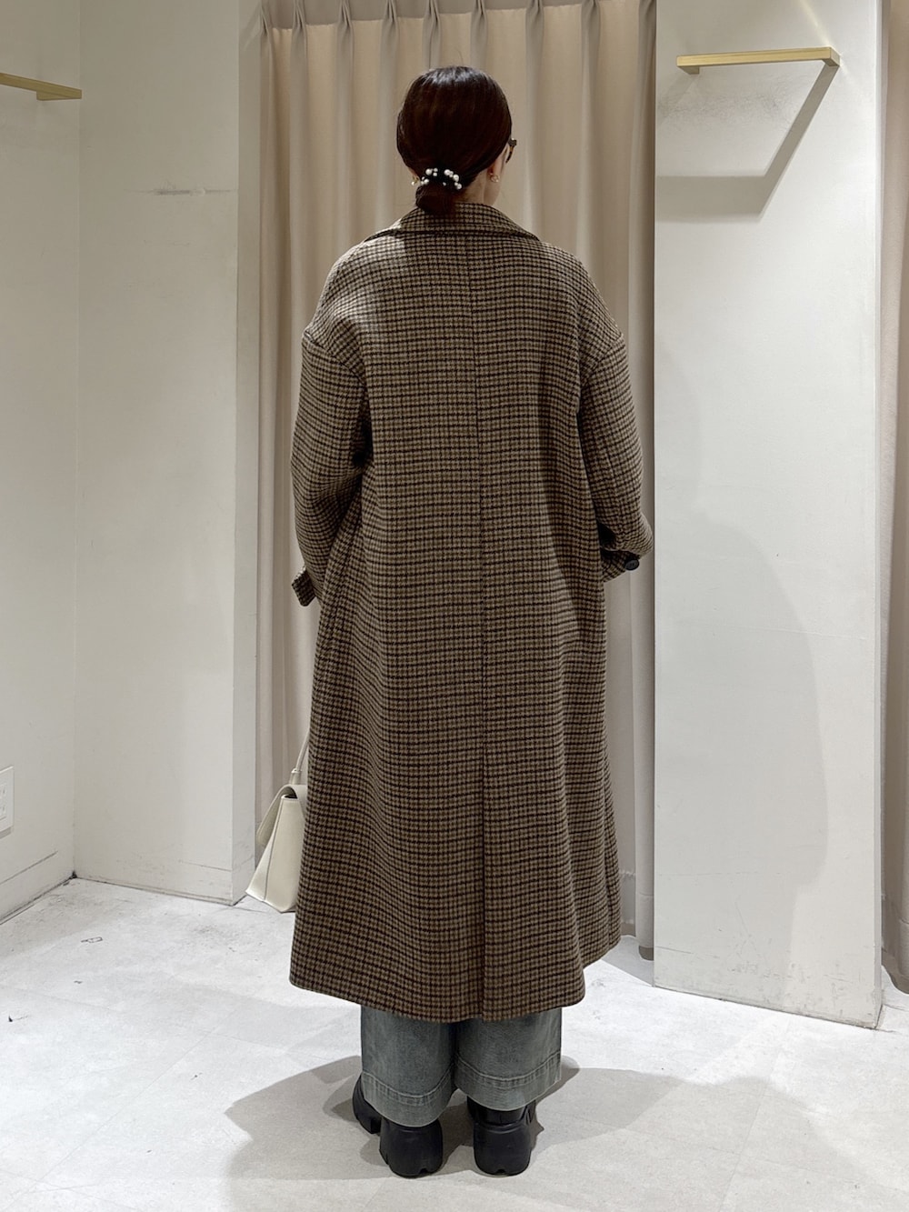 ベージュ系のチェスターコート、ホワイト系のニット/セーター、ホワイト系のショルダーバッグを着用したレディースの冬コーディネートの4枚目の写真