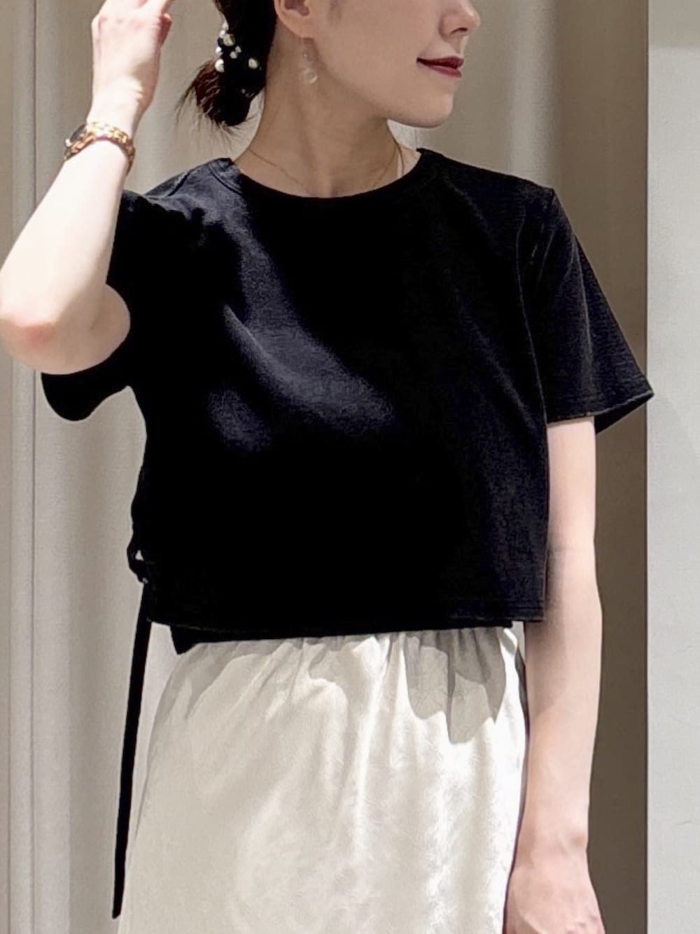 ブラック系のTシャツ/カットソー、ホワイト系のスカート、ピンク系のボストンバッグを着用したレディースの春コーディネートの5枚目の写真