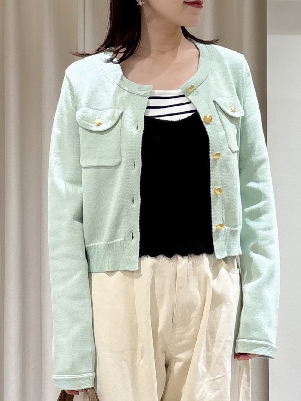 ブラック系のニット/セーター、グリーン系のニット/セーター、ホワイト系のニット/セーターを着用したレディースの春コーディネートの3枚目の写真