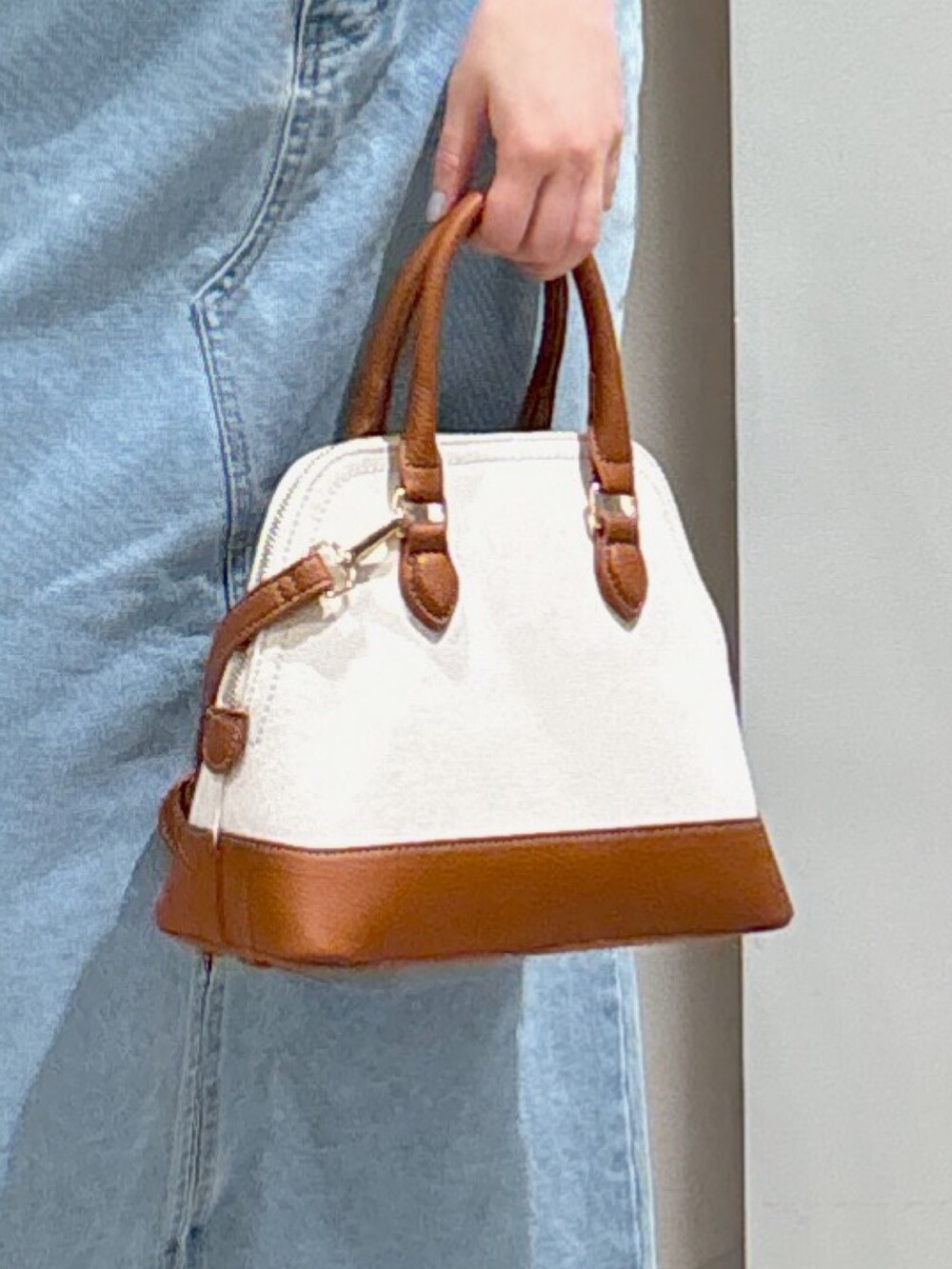 ホワイト系のベスト、ブルー系のデニムスカート、グレー系のサンダルを着用したレディースの春コーディネートの3枚目の写真