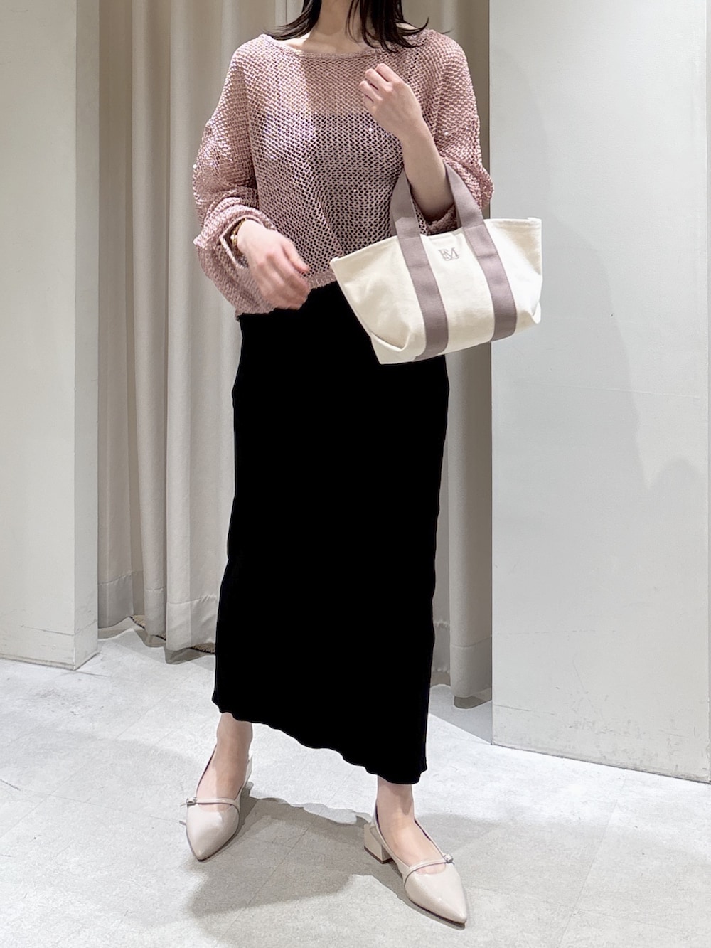ピンク系のニット/セーター、ブラック系のキャミソール、グレー系のトートバッグを着用したレディースの春コーディネートの4枚目の写真