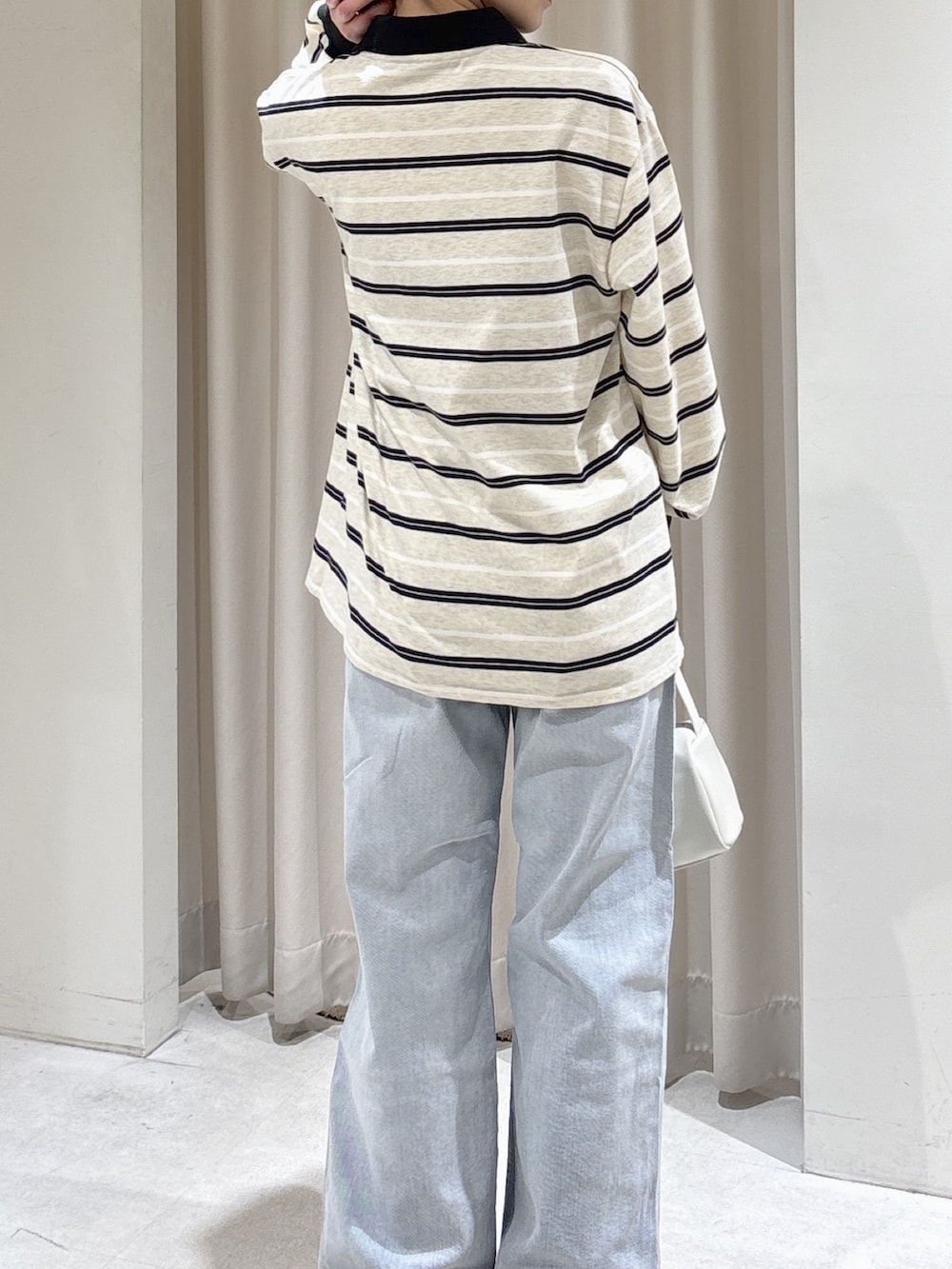 グレー系のTシャツ/カットソー、ホワイト系のハンドバッグ、ブルー系のデニムパンツを着用したレディースの春コーディネートの5枚目の写真