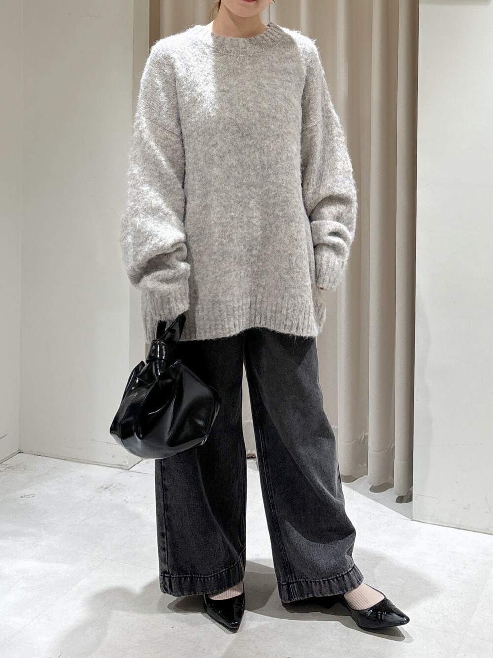 ブラウン系のブルゾン、ブラック系のデニムパンツ、ブラック系のハンドバッグを着用したレディースの秋コーディネートの6枚目の写真