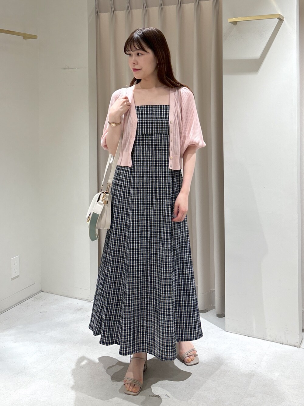 ブラック系のワンピース、ピンク系のカーディガン/ボレロ、ホワイト系のショルダーバッグを着用したレディースの春コーディネートの3枚目の写真