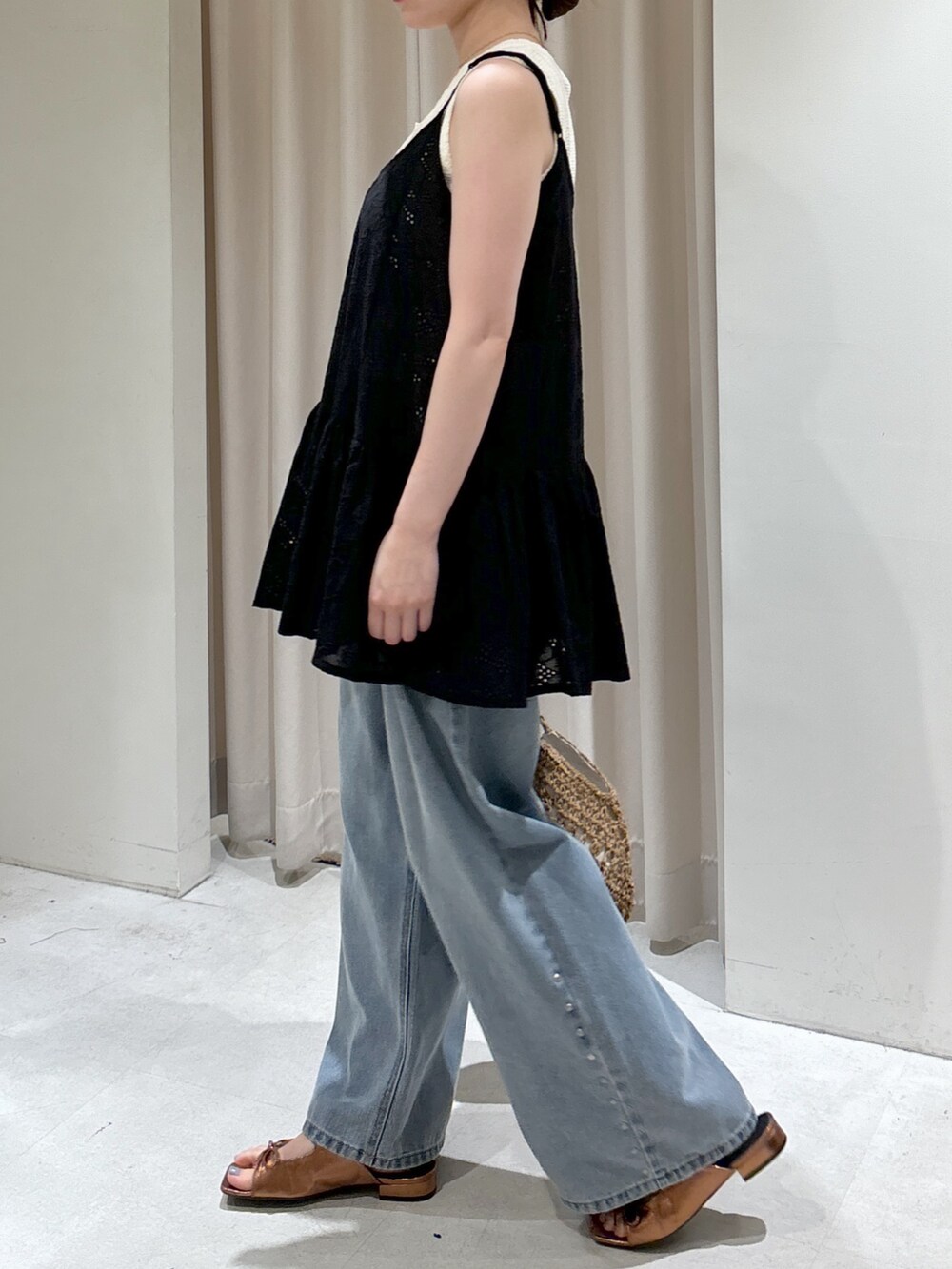 ブラック系のシャツ/ブラウス、ホワイト系のニット/セーター、ベージュ系のトートバッグを着用したレディースの春コーディネートの2枚目の写真