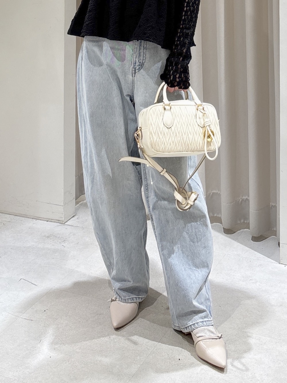 ブラック系のシャツ/ブラウス、ブラック系のTシャツ/カットソー、ホワイト系のボストンバッグを着用したレディースの春コーディネートの3枚目の写真