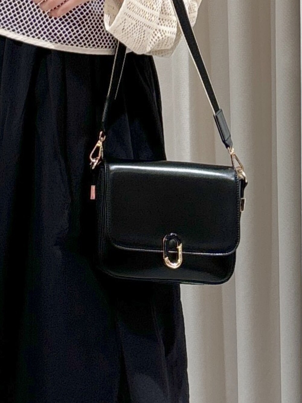 ホワイト系のカーディガン/ボレロ、ブラック系のワンピース、ブラック系のショルダーバッグを着用したレディースの秋コーディネートの6枚目の写真