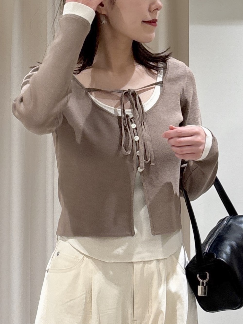 ブラウン系のニット/セーター、ホワイト系のその他パンツ、ブラック系のサンダルを着用したレディースの春コーディネートの2枚目の写真