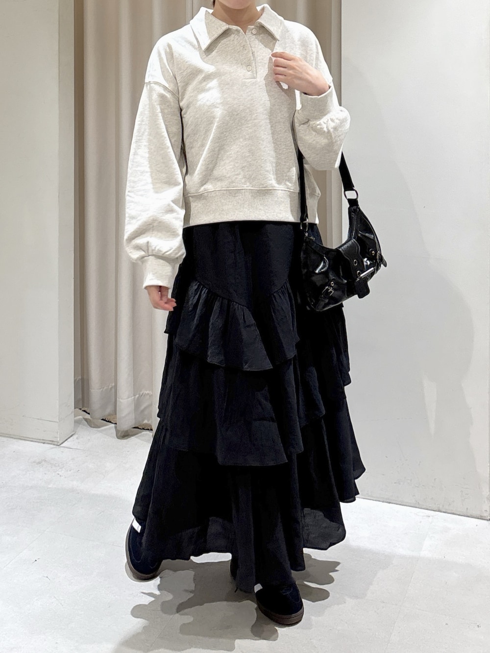 ホワイト系のスウェット、ブラック系のスカート、ブラック系のショルダーバッグを着用したレディースの秋コーディネートの6枚目の写真