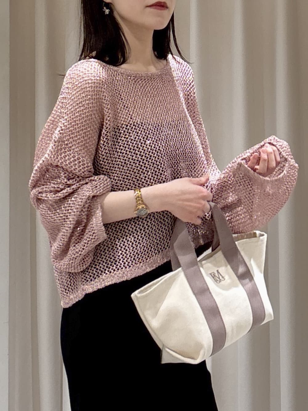 ピンク系のニット/セーター、ブラック系のキャミソール、グレー系のトートバッグを着用したレディースの春コーディネートの2枚目の写真