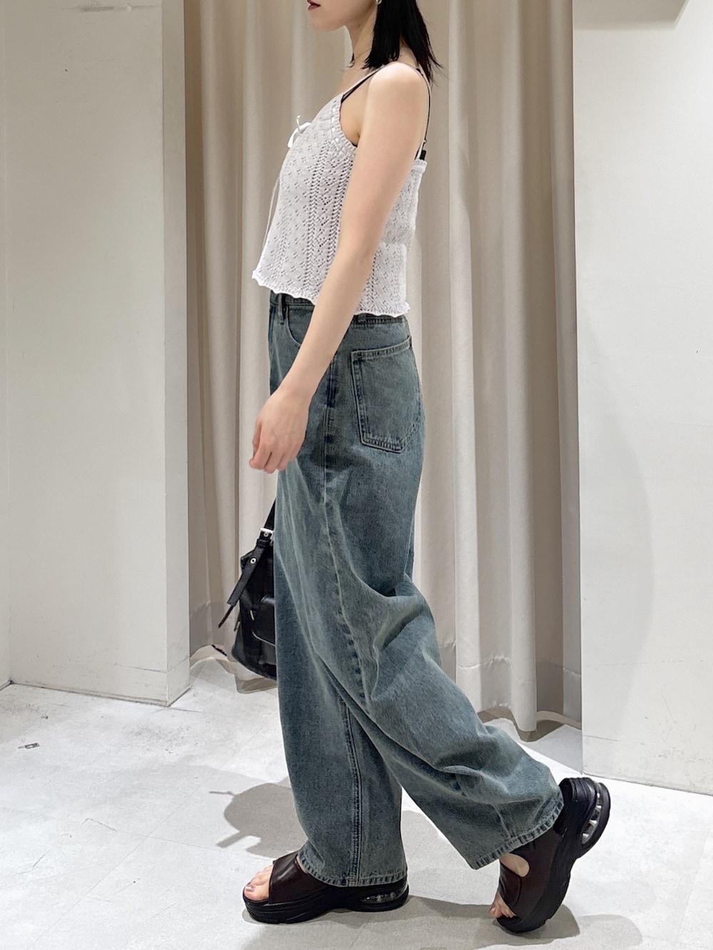 パープル系のニット/セーター、ホワイト系のTシャツ/カットソー、ホワイト系のハンドバッグを着用したレディースの夏コーディネートの3枚目の写真