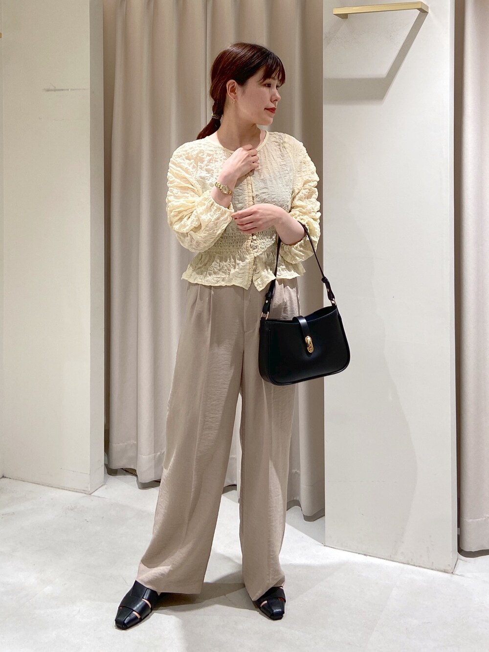ベージュ系のテーラードジャケット、ホワイト系のスラックス、ホワイト系のカーディガン/ボレロを着用したレディースの春コーディネートの5枚目の写真