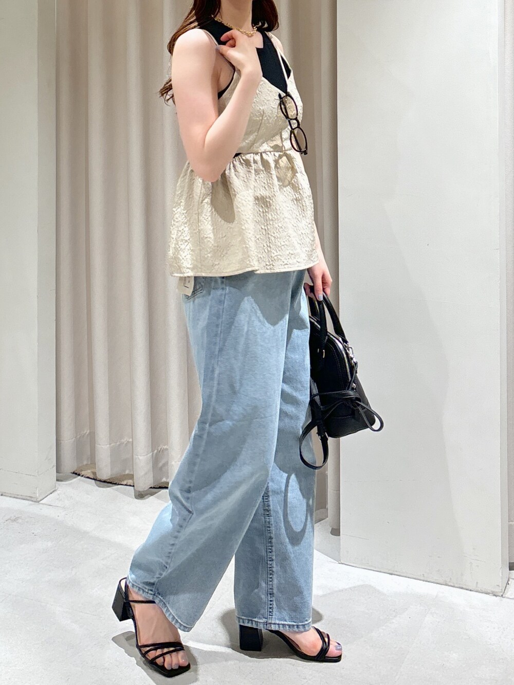 ホワイト系のシャツ/ブラウス、ブラック系のショルダーバッグ、ブルー系のデニムパンツを着用したレディースの夏コーディネートの5枚目の写真