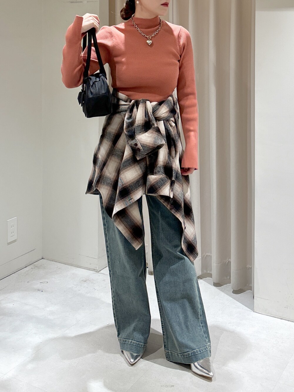 ブラウン系のシャツ/ブラウス、ピンク系のニット/セーター、ブラック系のトートバッグを着用したレディースの冬コーディネートの6枚目の写真