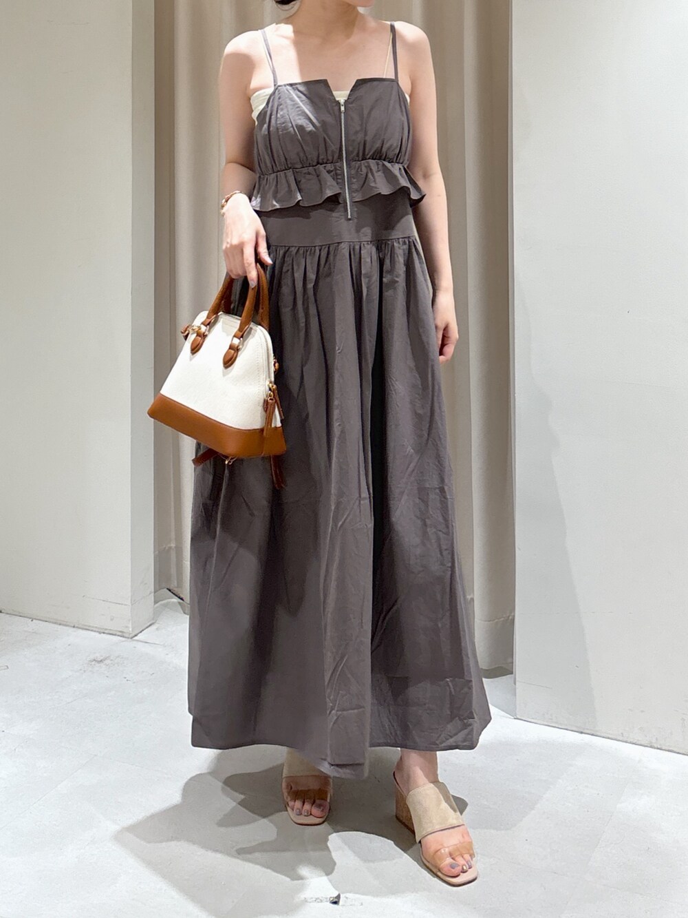 グレー系のワンピース、ブルー系のニット/セーター、ブラウン系のショルダーバッグを着用したレディースの夏コーディネートの4枚目の写真