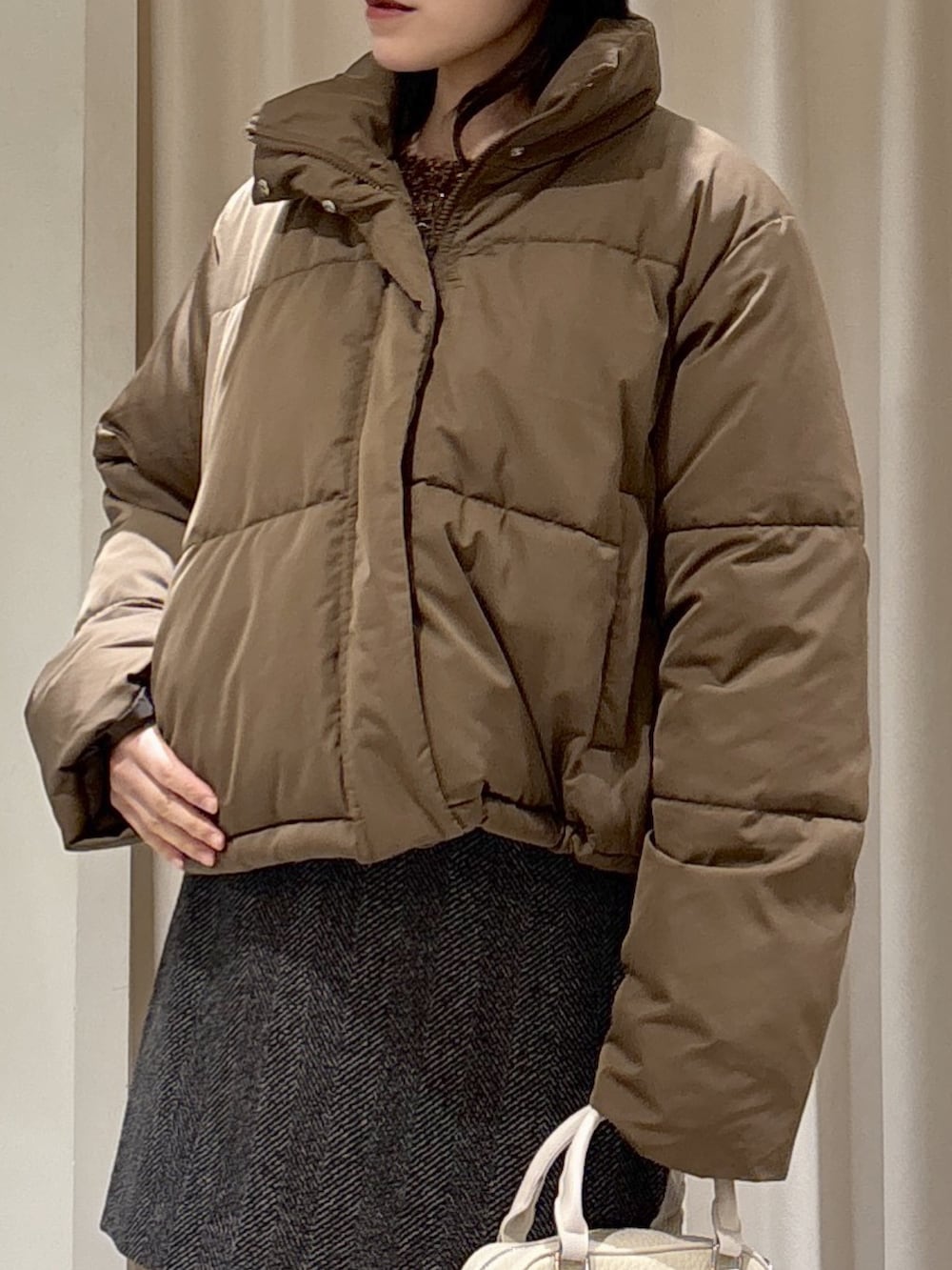 ブラウン系のニット/セーター、ブラック系のスカート、ブラック系のブーツを着用したレディースの冬コーディネートの10枚目の写真