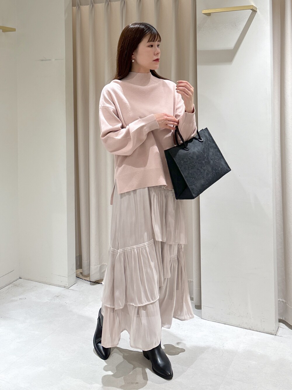 ホワイト系のスカート、ブラック系のその他アウター、ピンク系のニット/セーターを着用したレディースの冬コーディネートの6枚目の写真