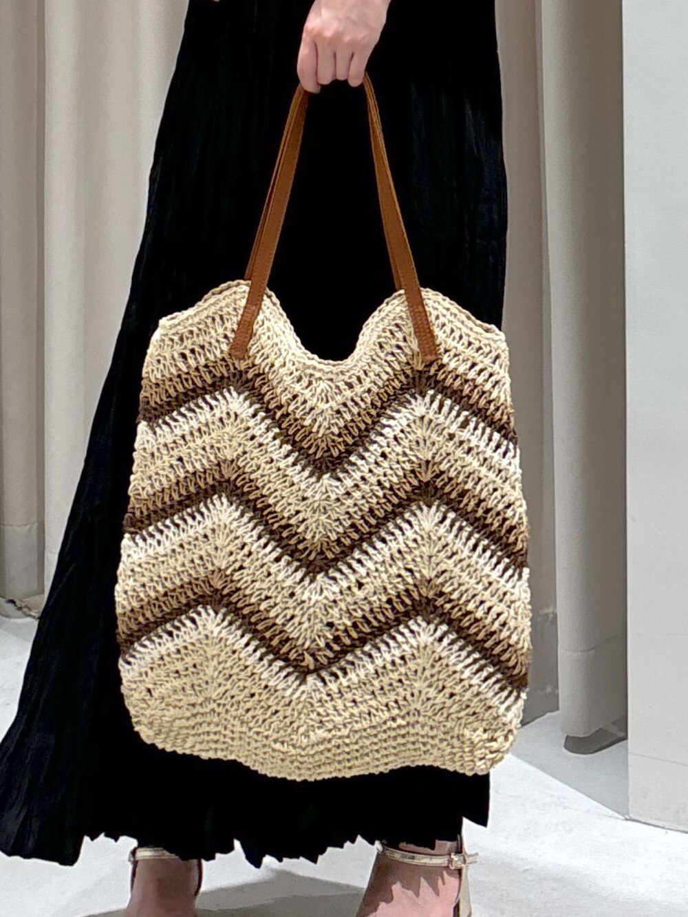 ブラック系のワンピース、ベージュ系のトートバッグ、ゴールド系のサンダルを着用したレディースの夏コーディネートの8枚目の写真