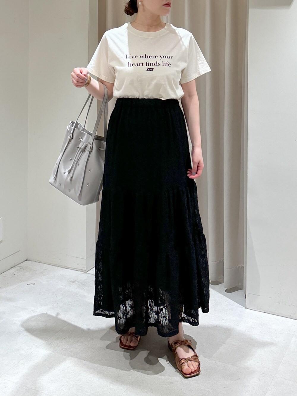 ホワイト系のTシャツ/カットソー、ブラック系のスカート、グレー系のトートバッグを着用したレディースの春コーディネートの3枚目の写真