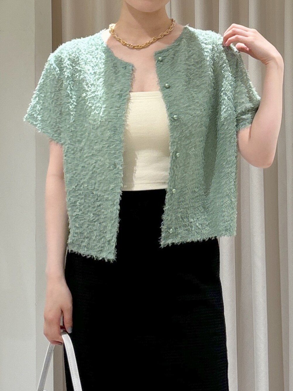 ブラック系のスカート、グレー系のサンダル、ホワイト系のハンドバッグを着用したレディースの夏コーディネートの5枚目の写真