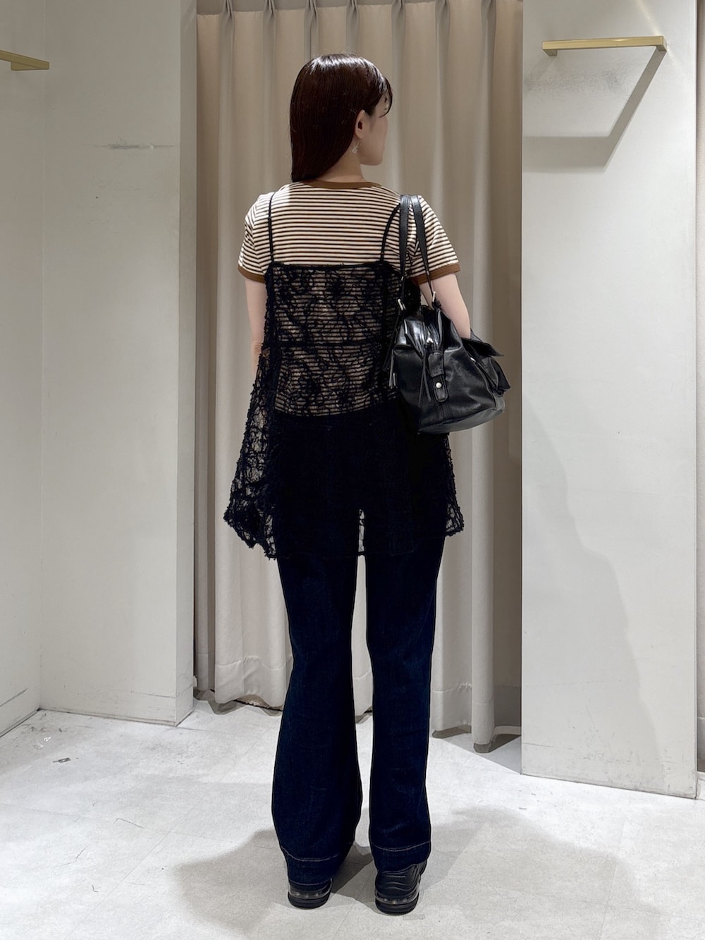 ブラック系のキャミソール、ブラウン系のTシャツ/カットソー、ブラック系のショルダーバッグを着用したレディースの春コーディネートの3枚目の写真
