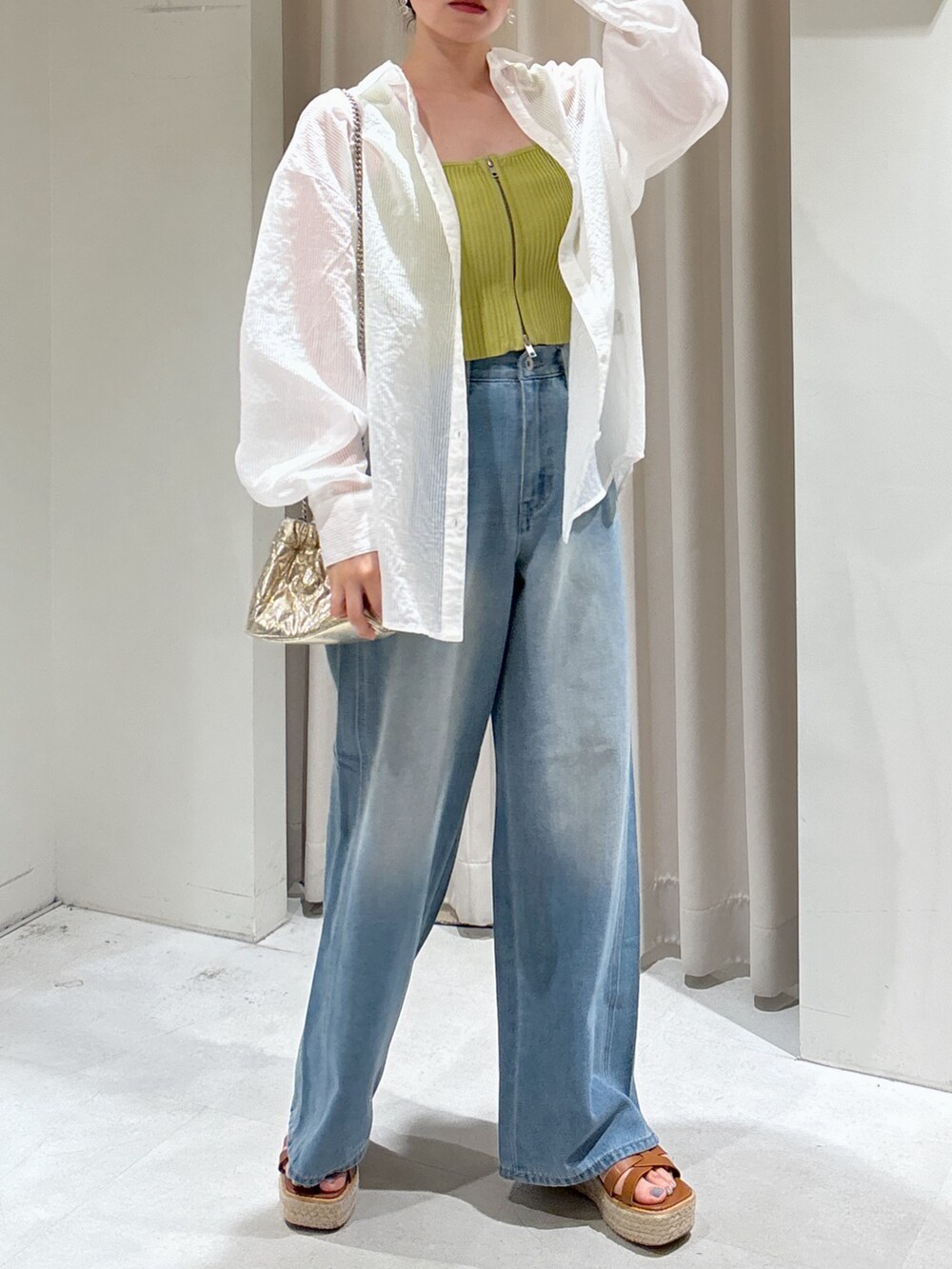 グリーン系のニット/セーター、ブルー系のデニムパンツ、ホワイト系のシャツ/ブラウスを着用したレディースの夏コーディネートの2枚目の写真