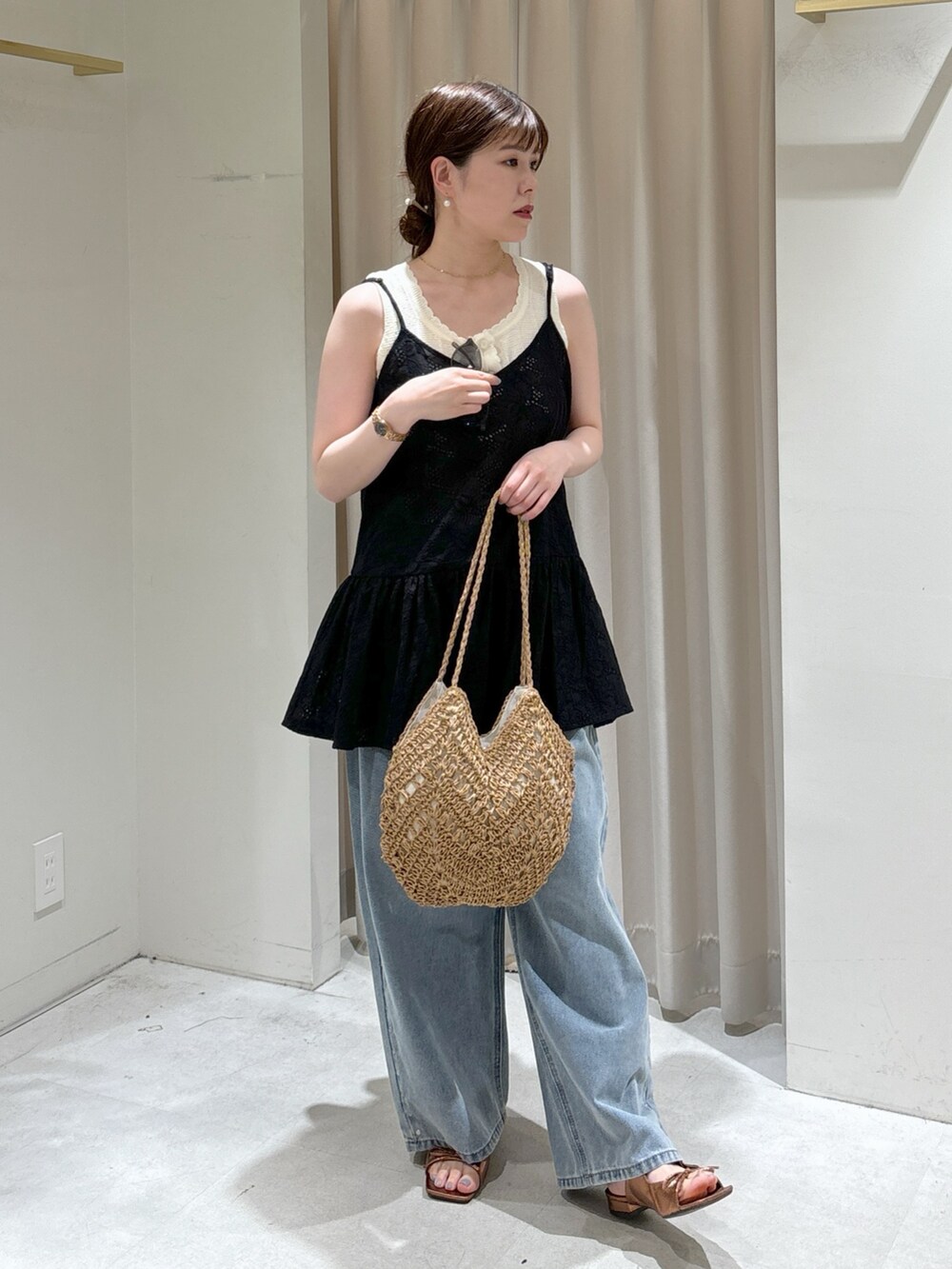 ブラック系のシャツ/ブラウス、ホワイト系のニット/セーター、ベージュ系のトートバッグを着用したレディースの春コーディネートの7枚目の写真