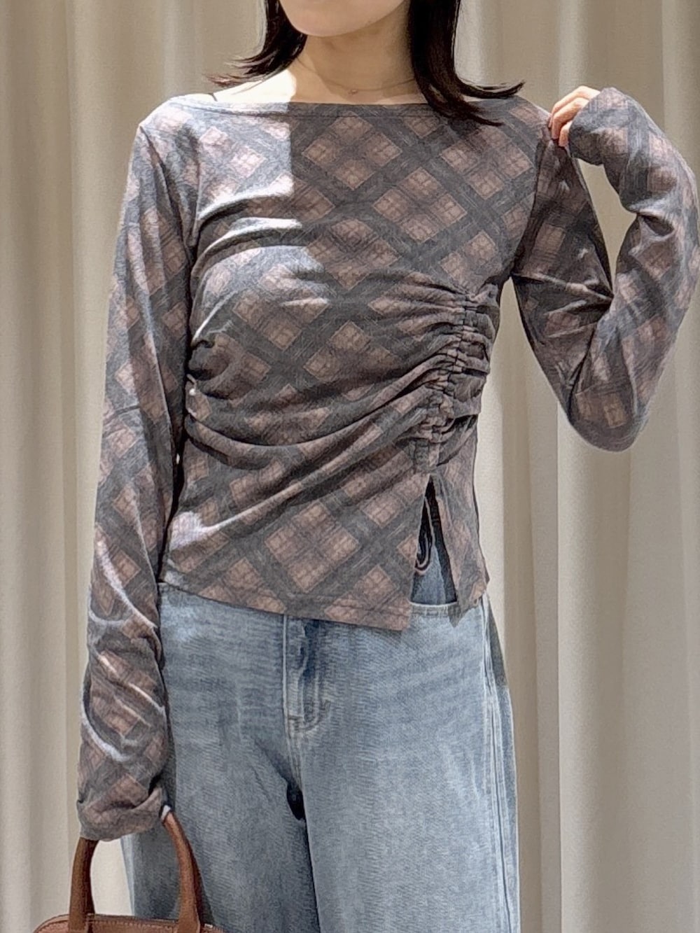 ブラウン系のTシャツ/カットソー、ブルー系のデニムパンツ、ブラウン系のショルダーバッグを着用したレディースの秋コーディネートの4枚目の写真