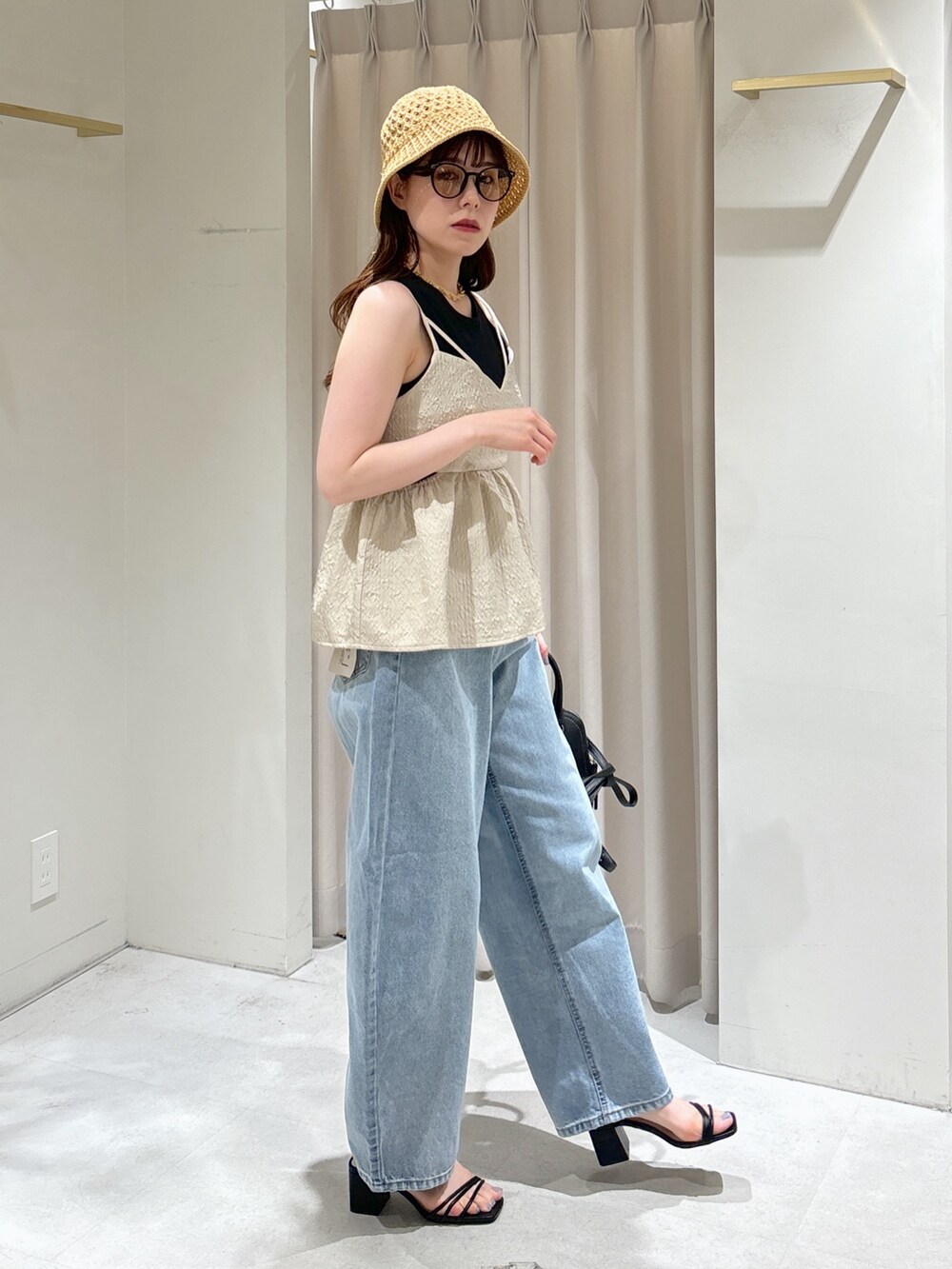 ホワイト系のシャツ/ブラウス、ブラック系のショルダーバッグ、ブルー系のデニムパンツを着用したレディースの夏コーディネートの2枚目の写真