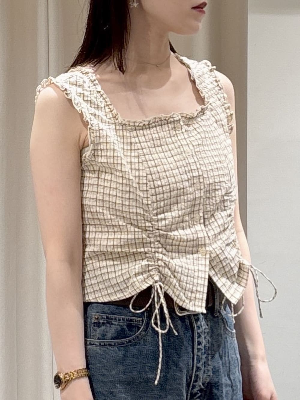 ベージュ系のシャツ/ブラウス、ブルー系のデニムパンツ、ブラウン系のハンドバッグを着用したレディースの春コーディネートの3枚目の写真