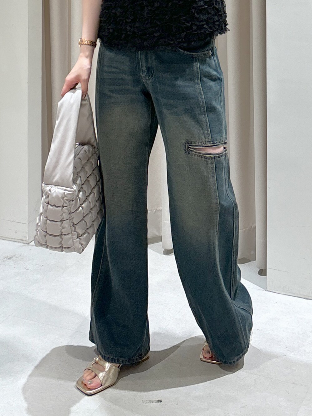 ブラック系のシャツ/ブラウス、ホワイト系のハンドバッグ、ブルー系のデニムパンツを着用したレディースの秋コーディネートの4枚目の写真