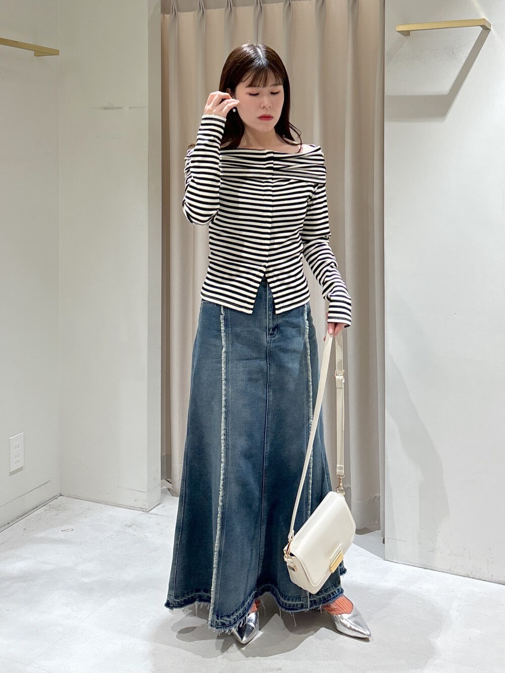 ホワイト系のTシャツ/カットソー、ブルー系のスカート、ホワイト系のショルダーバッグを着用したレディースの春コーディネートの4枚目の写真