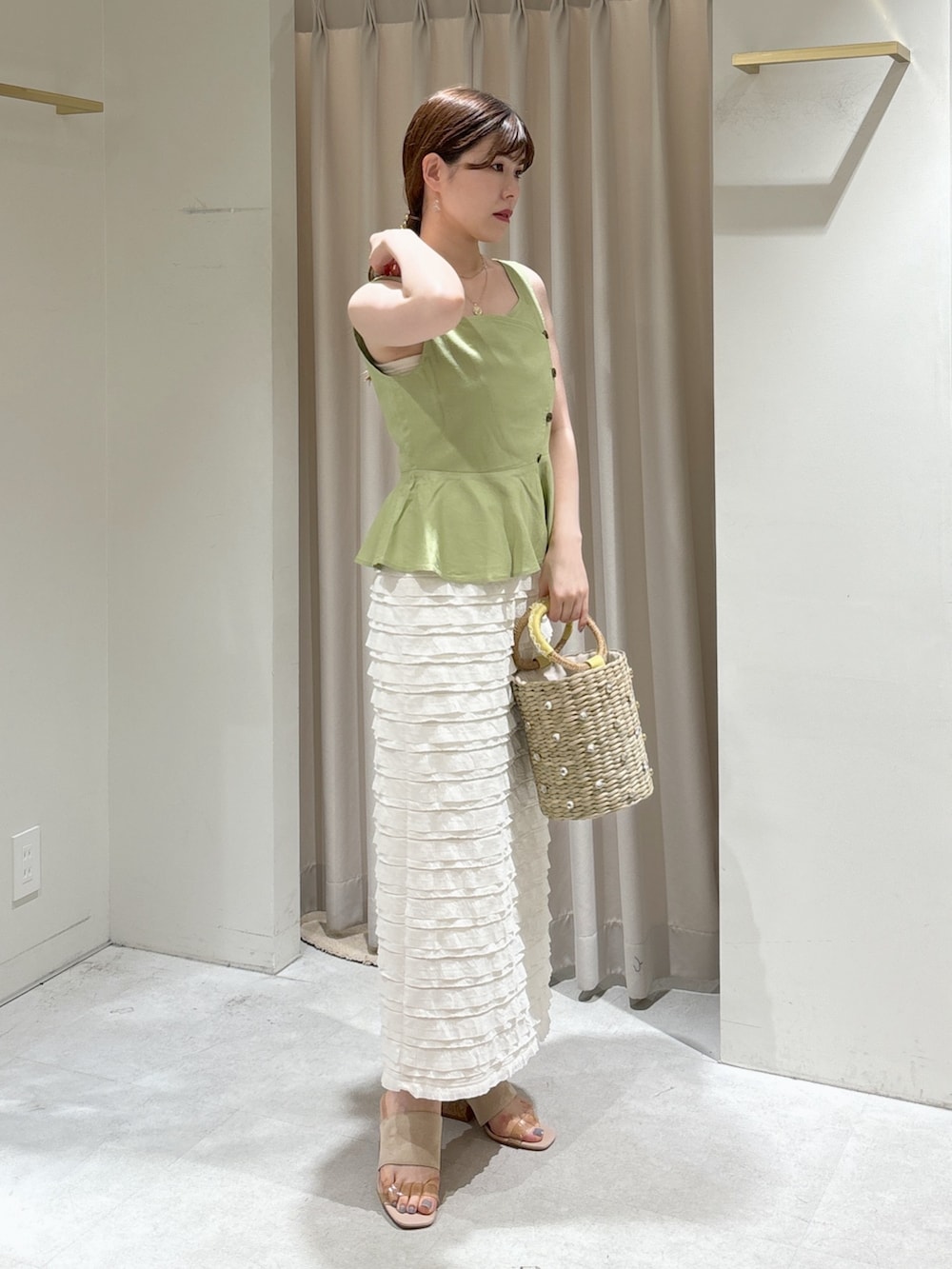 グリーン系のシャツ/ブラウス、ホワイト系のスカート、イエロー系のかごバッグを着用したレディースの夏コーディネートの2枚目の写真