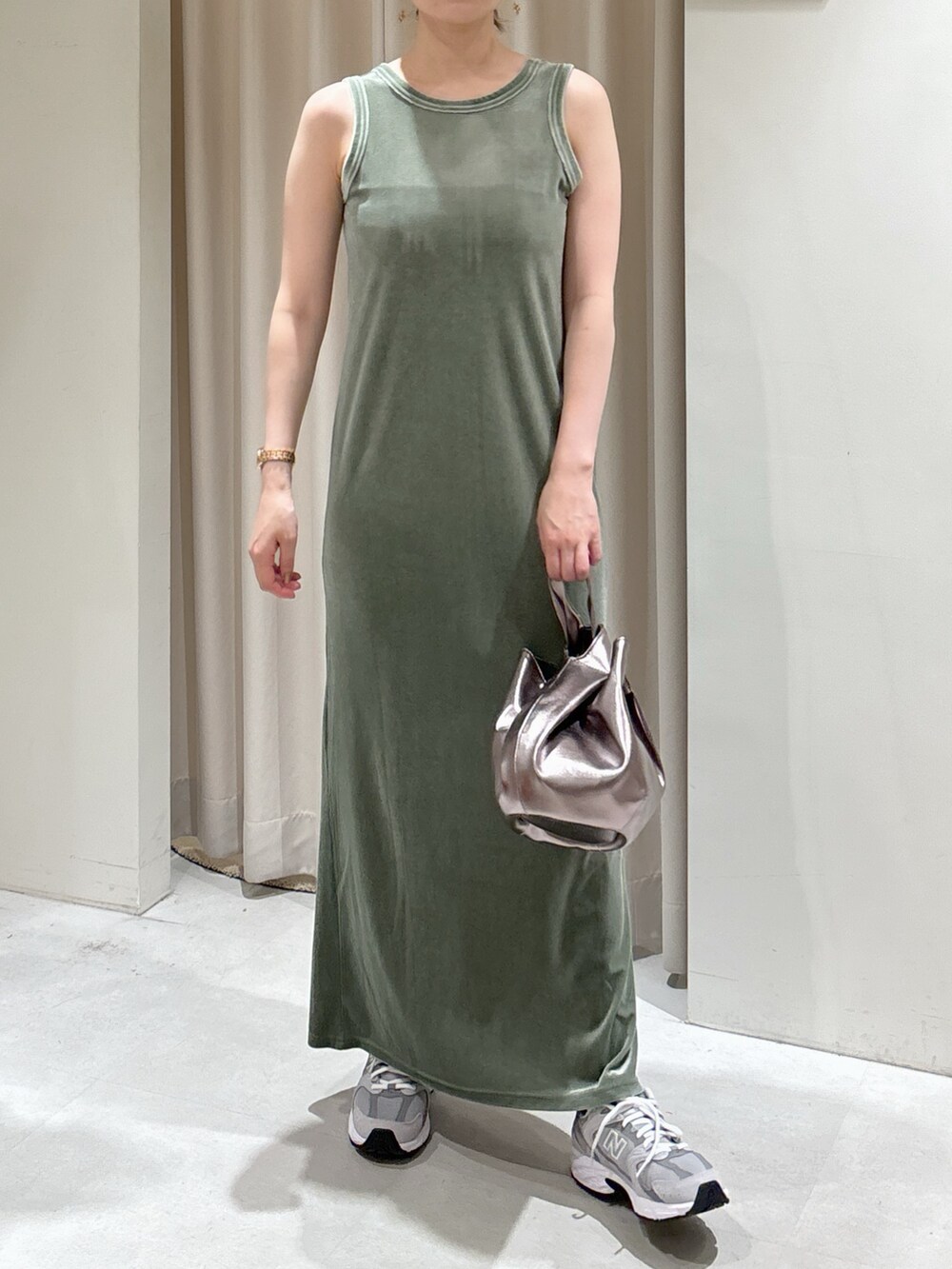 グリーン系のワンピース、シルバー系のハンドバッグ、グレー系のスニーカーを着用したレディースの秋コーディネートの5枚目の写真